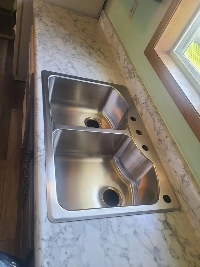 Stainless double sink set into a marble-look laminate countertop